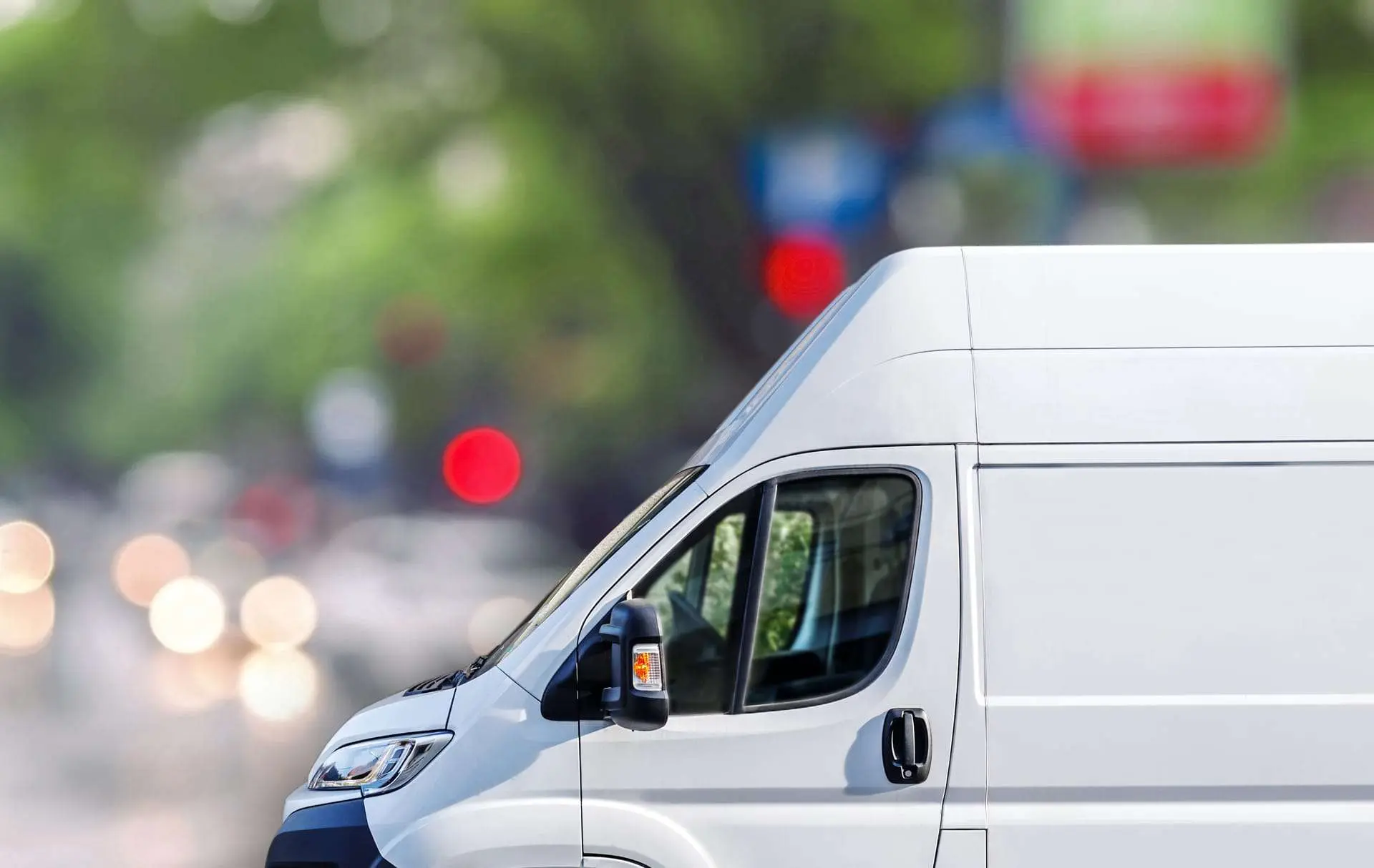 Front of a white transit style van with a blured background