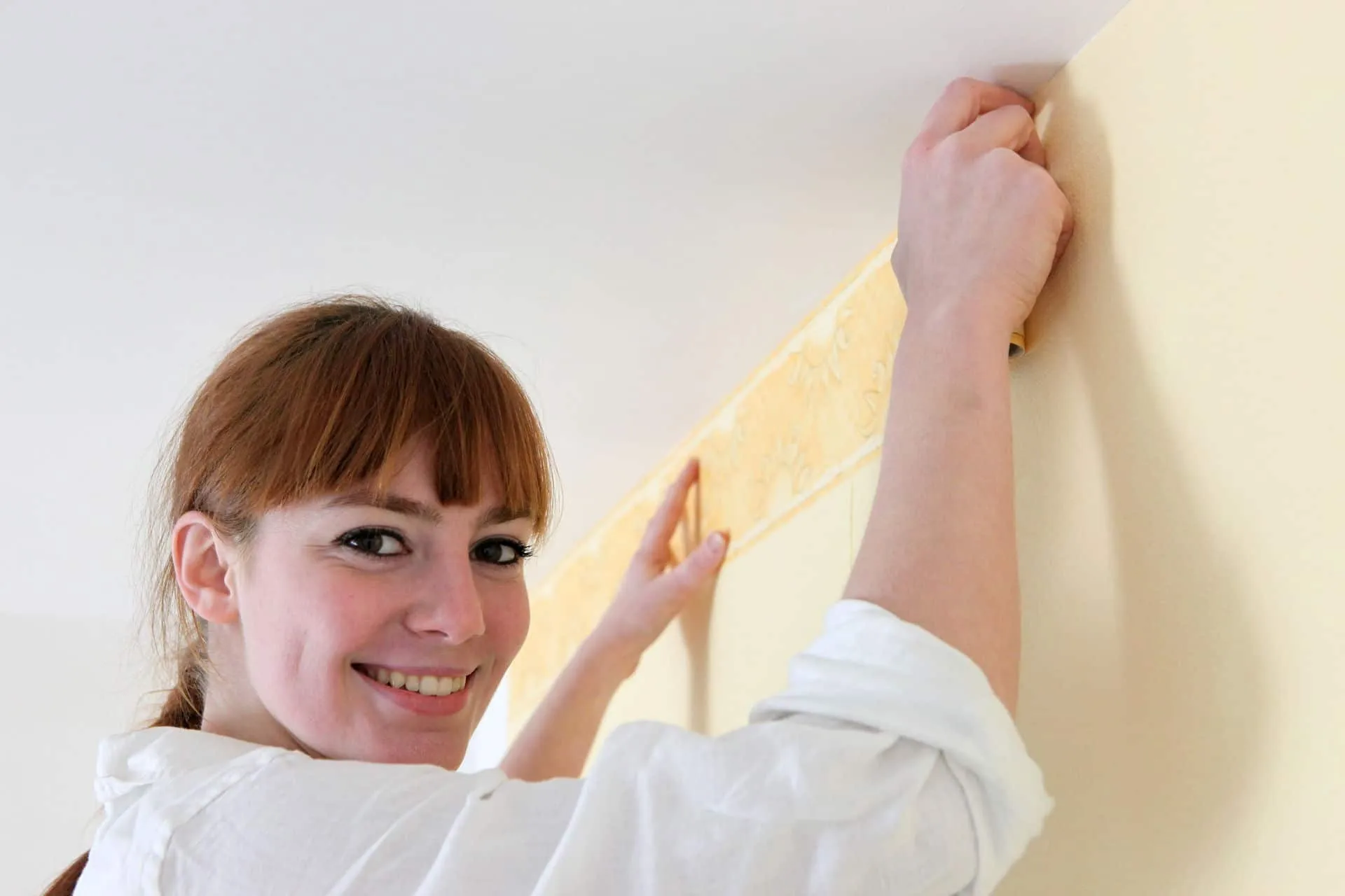 woman decorater hanging wall paper